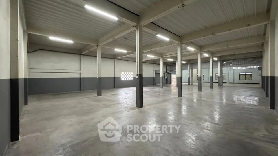 Spacious industrial warehouse with high ceilings and ample natural light, perfect for storage or manufacturing.