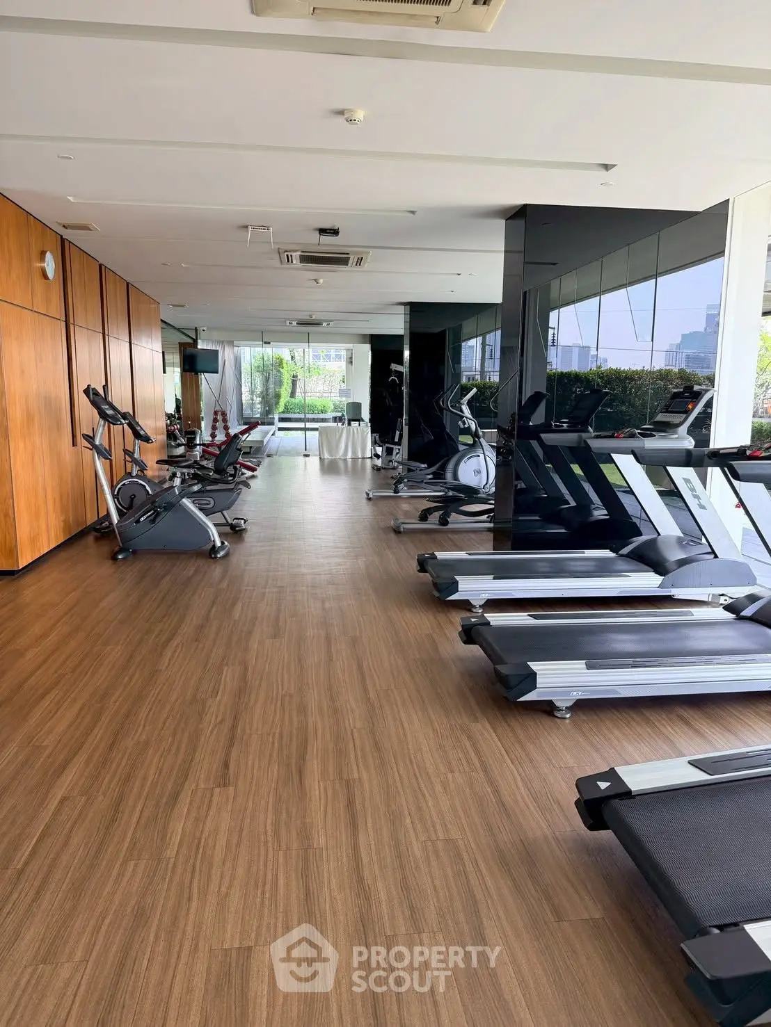 Spacious modern gym with state-of-the-art equipment and large windows offering a scenic view.