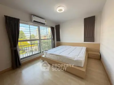 Bright bedroom with large window and modern furnishings