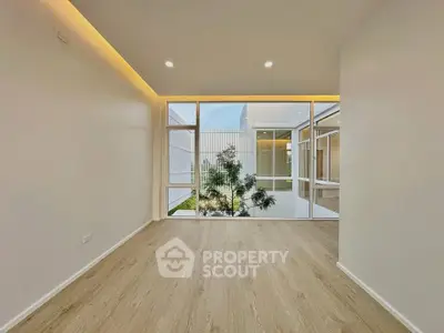 Spacious modern room with large windows and wooden flooring