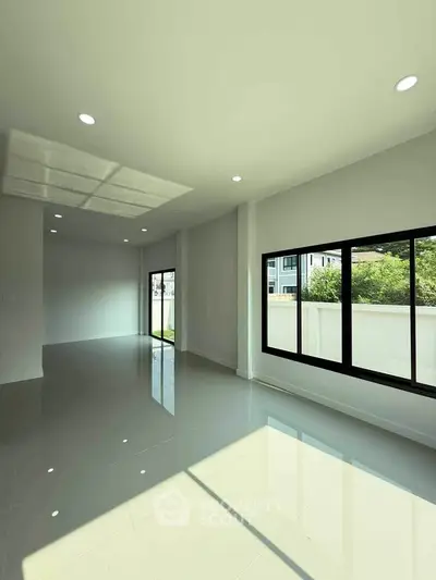 Spacious modern living room with large windows and natural light