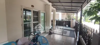 Charming covered patio with seating area and garden view, perfect for relaxation and outdoor gatherings.