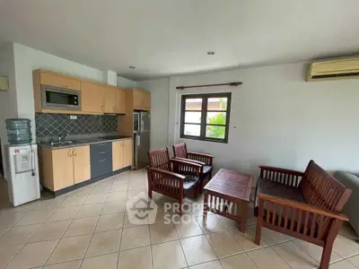 Charming open-layout living room with modern kitchen and cozy seating area.