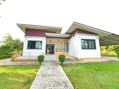Modern single-story house with large windows and lush green lawn, perfect for family living.