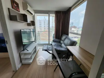 Modern living room with sleek furniture and city view, featuring a large TV and comfortable seating.