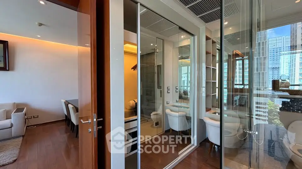Luxurious modern apartment interior with glass walls and elegant furnishings in a high-rise building.