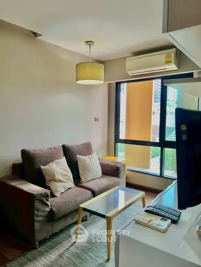 Modern living room with cozy sofa and city view window in a stylish apartment.