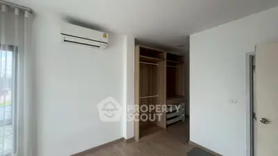 Spacious bedroom with built-in wardrobe and air conditioning unit.