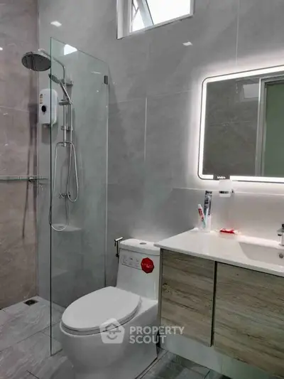 Modern bathroom with sleek shower and illuminated mirror