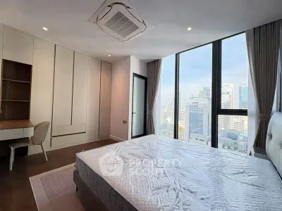 Modern bedroom with city view, featuring built-in wardrobe and study desk.