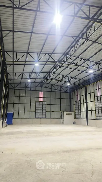 Spacious industrial warehouse with high ceilings and ample lighting, perfect for storage or manufacturing needs.