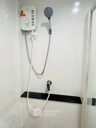 Modern bathroom with sleek shower unit and white tiled walls, perfect for a contemporary home.