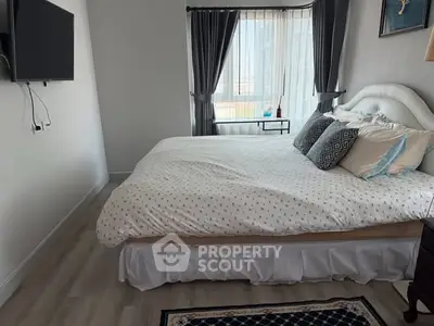 Spacious bedroom with elegant decor and large window offering natural light.