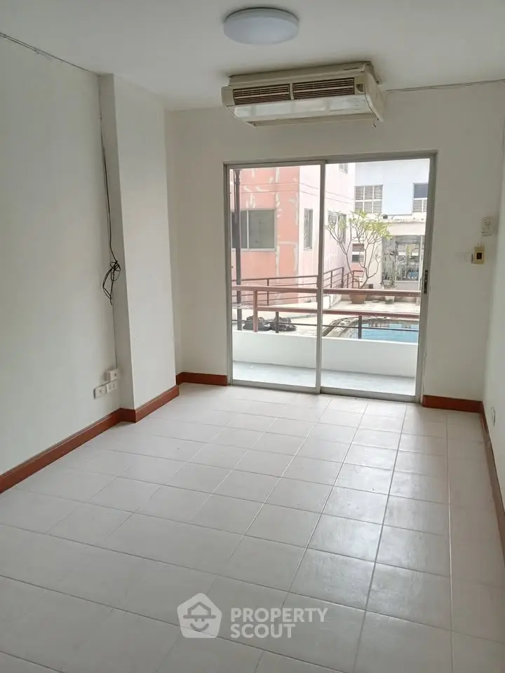 Bright empty room with air conditioning and balcony access in modern apartment.