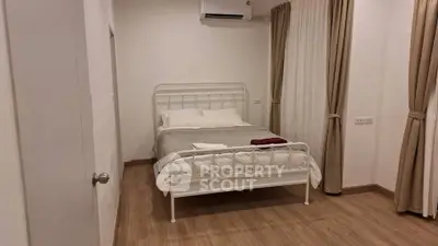 Cozy bedroom with elegant curtains and modern air conditioning unit.