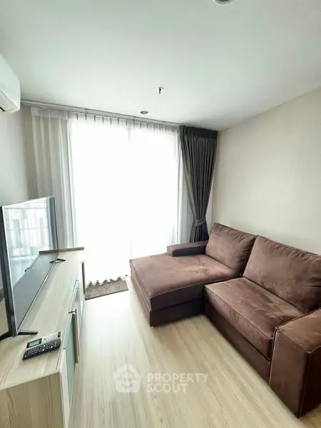 Modern living room with brown sofa and large window, perfect for relaxation.