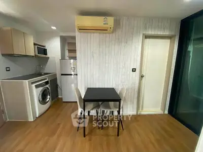 Modern kitchen with washing machine and dining area in stylish apartment