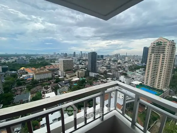 Stunning cityscape view from a high-rise balcony showcasing urban skyline and lush greenery.