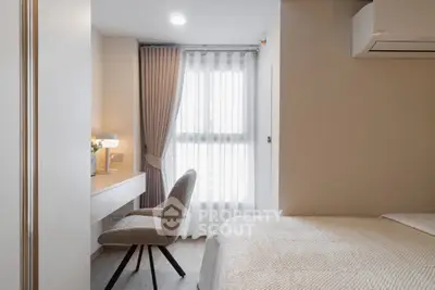 Modern bedroom with cozy decor and natural light, featuring a stylish desk and chair by the window.