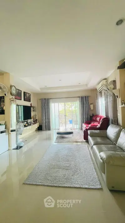 Spacious living room with modern decor and large windows offering natural light.