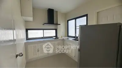 Modern kitchen with sleek cabinets and large windows for natural light.