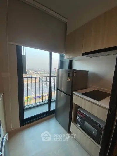 Modern kitchen with sleek appliances and balcony view in a stylish apartment.