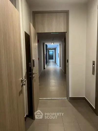 Modern apartment hallway with open doors and elevator access