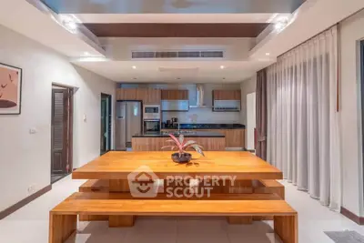 Modern kitchen with wooden dining table and sleek appliances in open layout