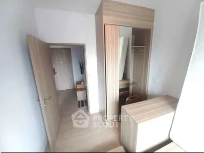 Modern bedroom with wooden wardrobe and open door, minimalist design.