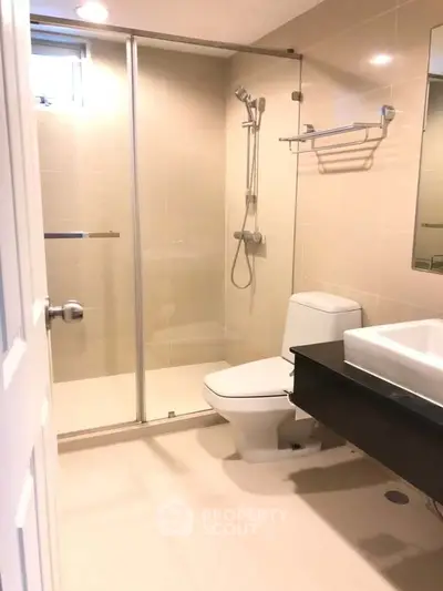Modern bathroom with glass shower enclosure and sleek fixtures