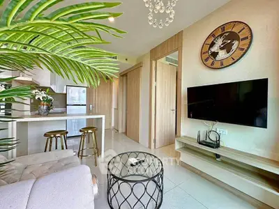 Modern living room with stylish decor, open kitchen, and wall-mounted TV in a cozy apartment.