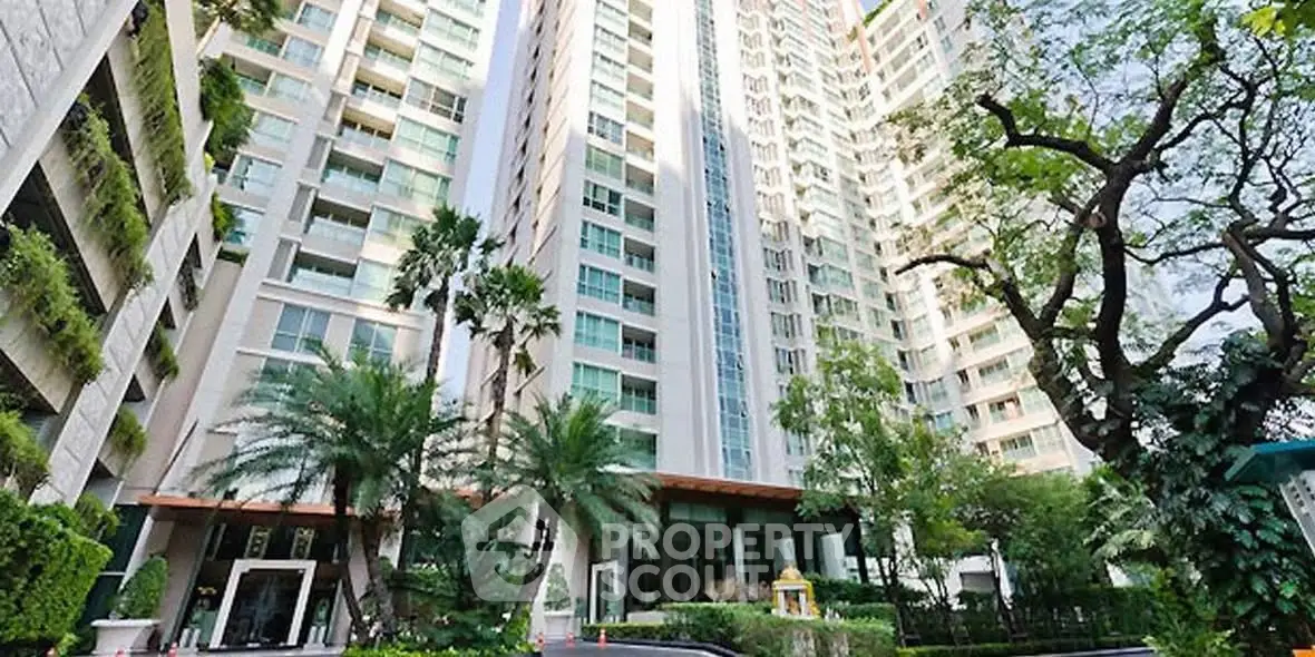 Luxurious high-rise building with lush greenery and modern architecture.