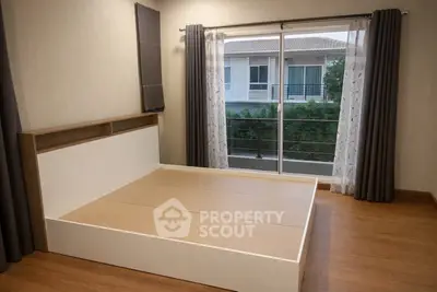 Spacious bedroom with large window and balcony view in modern home