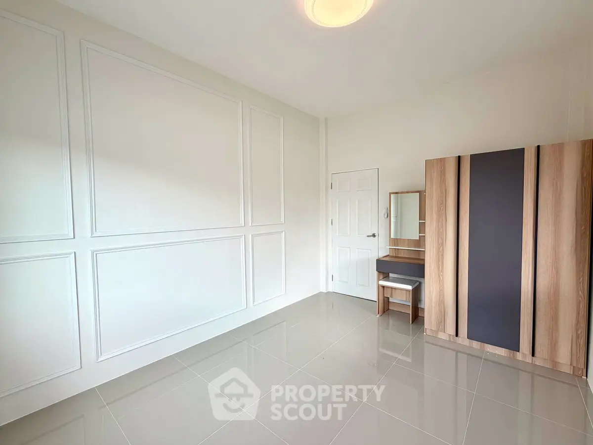 Spacious empty room with modern wardrobe and sleek tile flooring, perfect for customization.