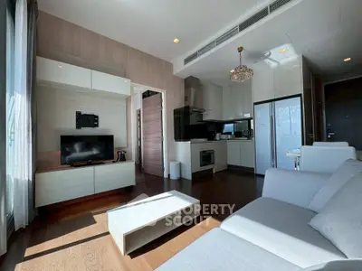 Modern living room with sleek furniture and open kitchen layout, featuring a cozy ambiance and natural light.