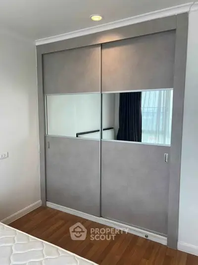 Modern bedroom with sleek built-in wardrobe and wooden flooring