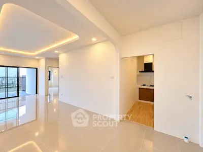 Modern open-plan living area with sleek kitchen and balcony access