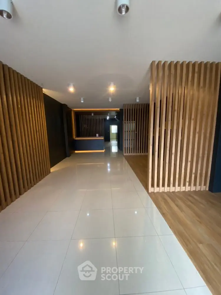 Modern building entrance with sleek wooden panel design and polished flooring.