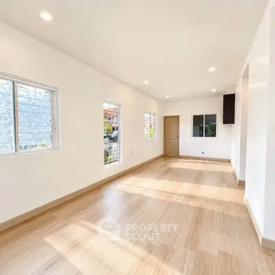 Spacious and bright living room with large windows and modern flooring