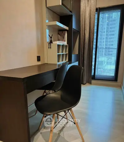 Modern study room with sleek desk and chair, large window offering city view, perfect for productivity.