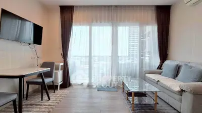 Modern living room with large window and stylish furniture in a high-rise apartment.