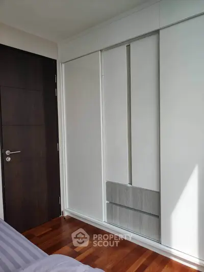 Modern bedroom with sleek built-in wardrobe and wooden flooring