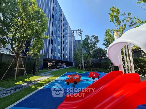 Modern apartment building with vibrant playground and lush greenery