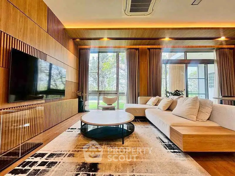 Luxurious modern living room with large windows and stylish wooden accents.