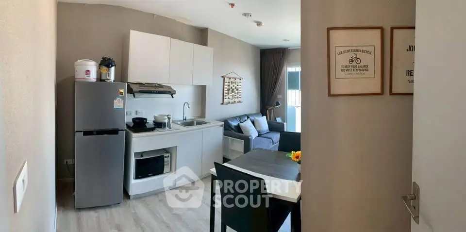 Modern apartment interior with compact kitchen and cozy living area, perfect for urban living.