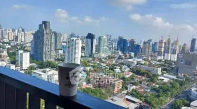 Stunning cityscape view from a high-rise balcony with a coffee mug in the foreground.
