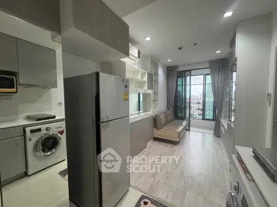 Modern apartment interior with open kitchen and living area, featuring city view from large windows.