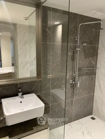 Modern bathroom with sleek design featuring a glass shower and elegant sink.