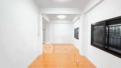 Spacious interior with tiled flooring and large windows in a modern apartment.