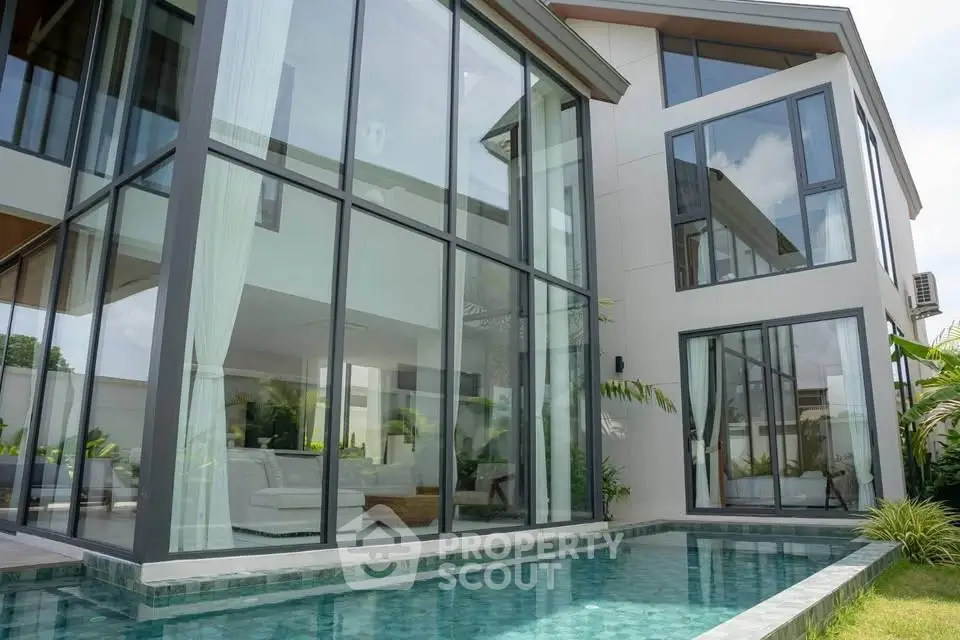 Luxurious modern home with floor-to-ceiling windows and private pool, showcasing contemporary architecture and elegant design.